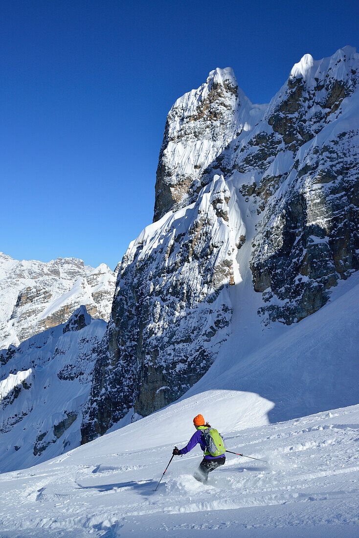 Female back-country skier downhill skiing from Cristallo wind gap, Cristallo, Dolomites, Belluno, Veneto, Italy