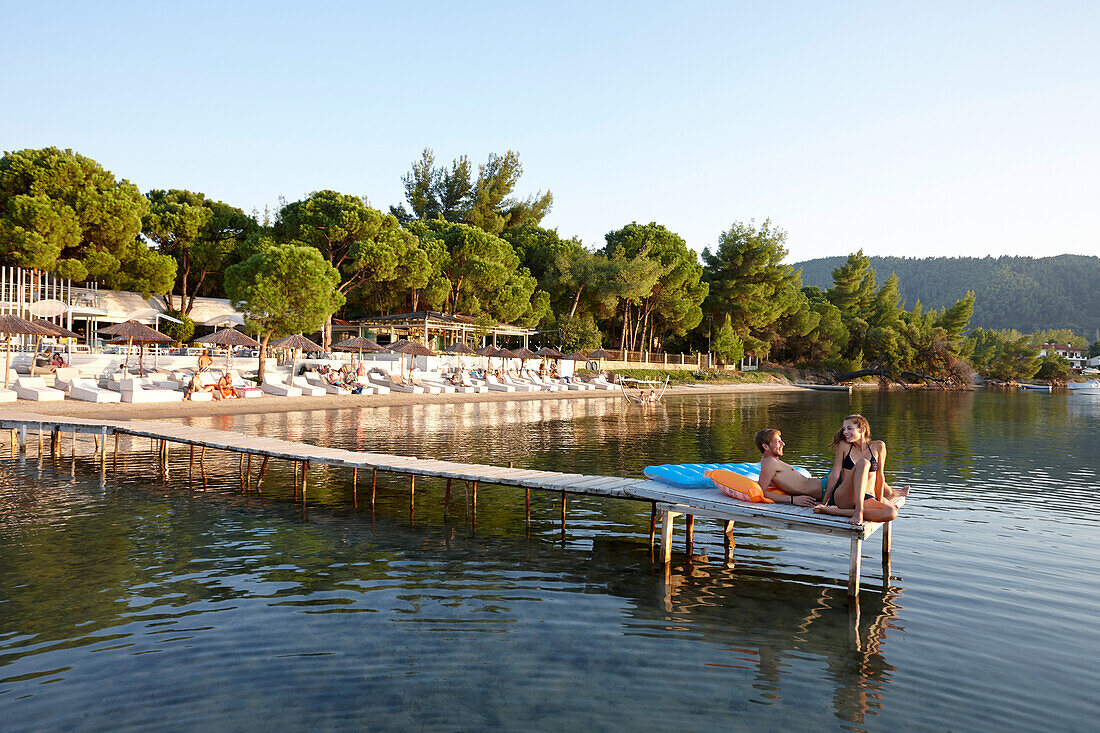Paar auf Steg am Hotelstrand, Ekies All Senses Resort, Vourvourou, Sithonia, Chalkidiki, Griechenland