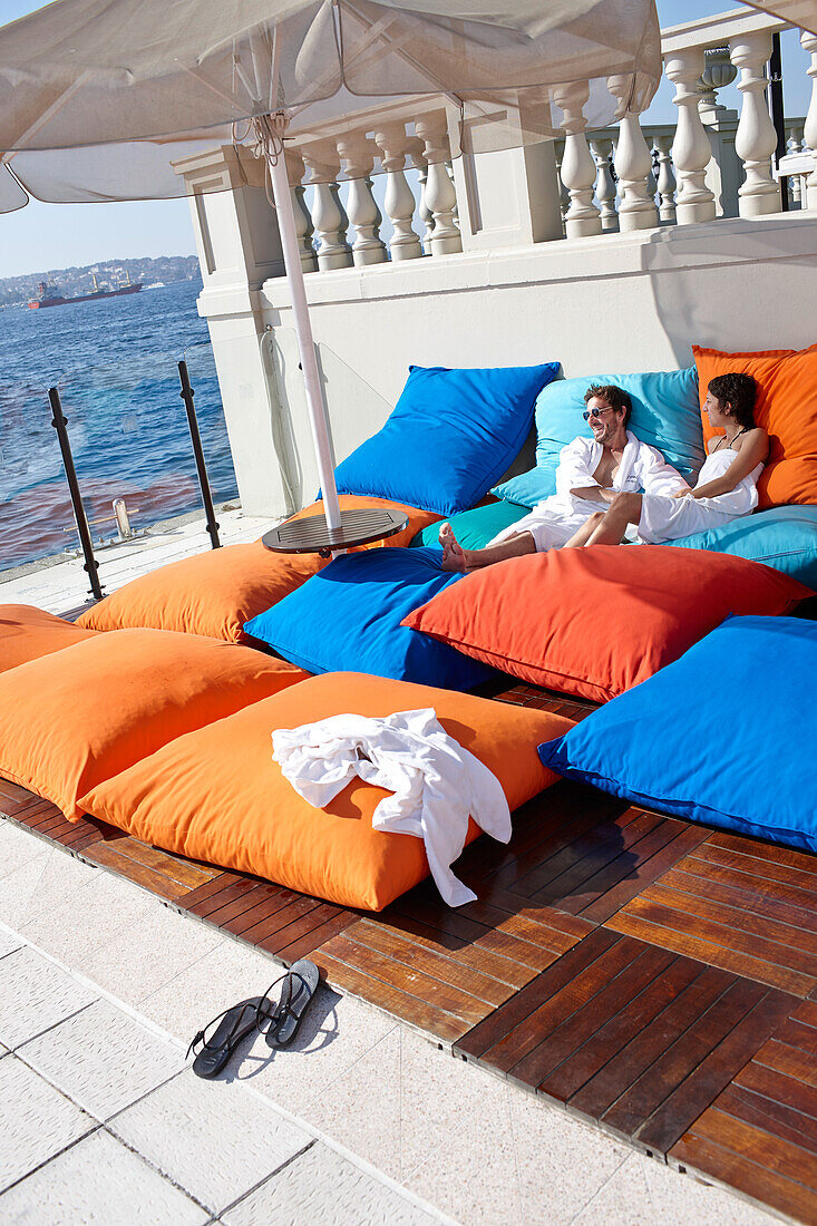 Gäste sonnen sich auf großen Sitzkissen auf der Poolterrasse, Hotel Ciragan Palace Kempinski, Bosporus Ufer, Istanbul, Türkei
