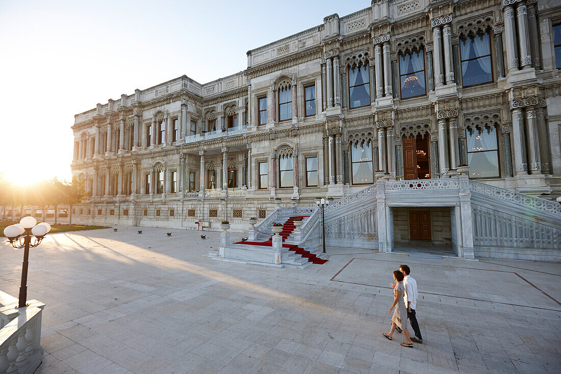 Couple strolling in the evening passing Ciragan Palace, Istanbul, Turkey