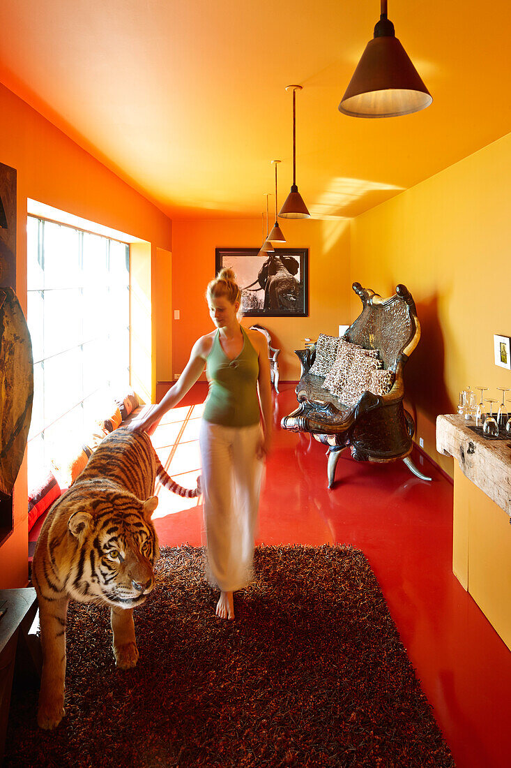 Woman touching a tiger figure in a hotel room, Saint-Saturnin-les-Apt, Provence, France