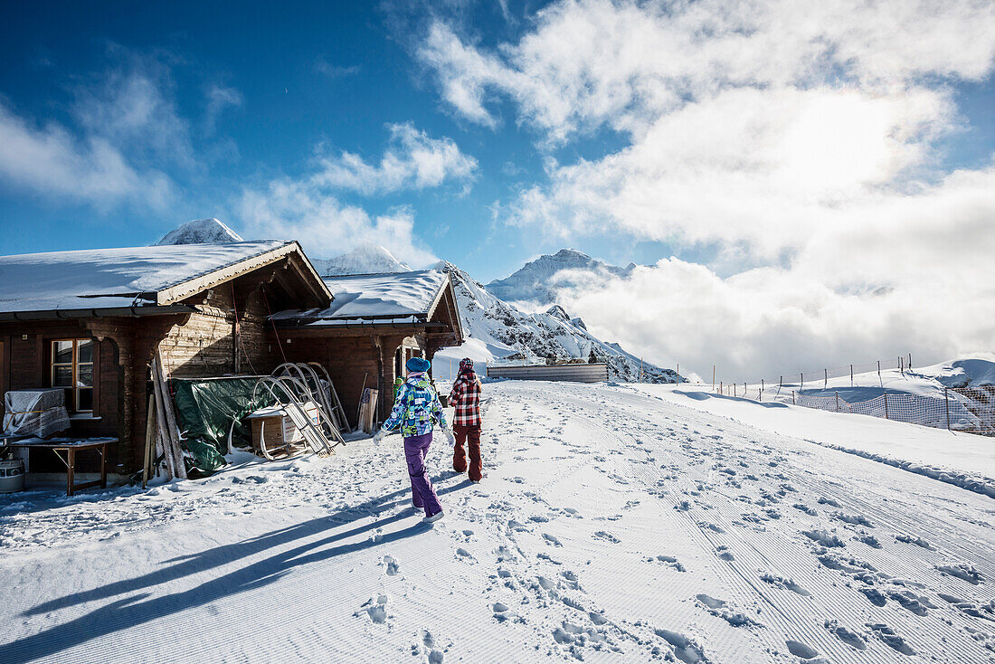 Timber hut in Winter on Maennlichen mountain with Eiger Moench and Jungfrau in the background, Grindelwald, canton of Bern, Switzerland