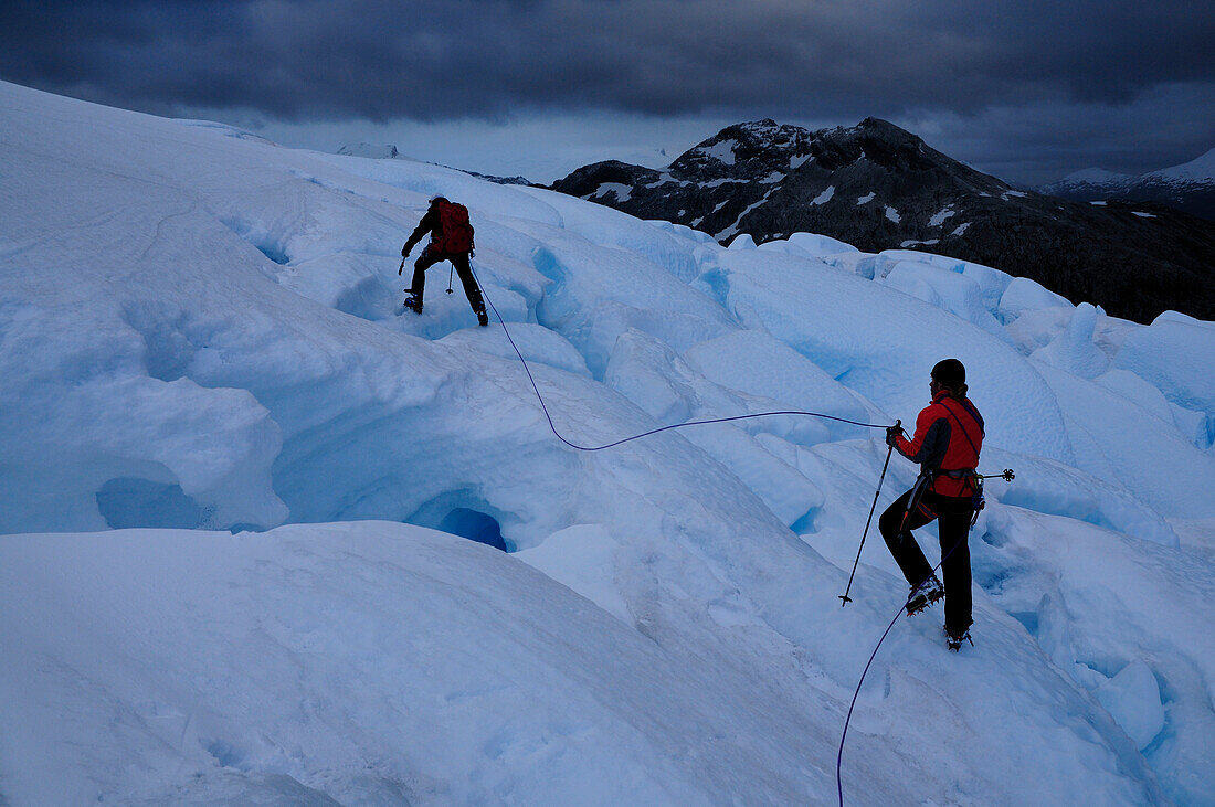 Two mountaineers passing a glacier, Monte Sarmiento, Cordillera Darwin, Tierra del Fuego, Chile