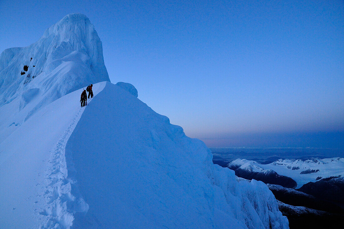 Two mountaineers below west summit of Monte Sarmiento, Cordillera Darwin, Tierra del Fuego, Chile