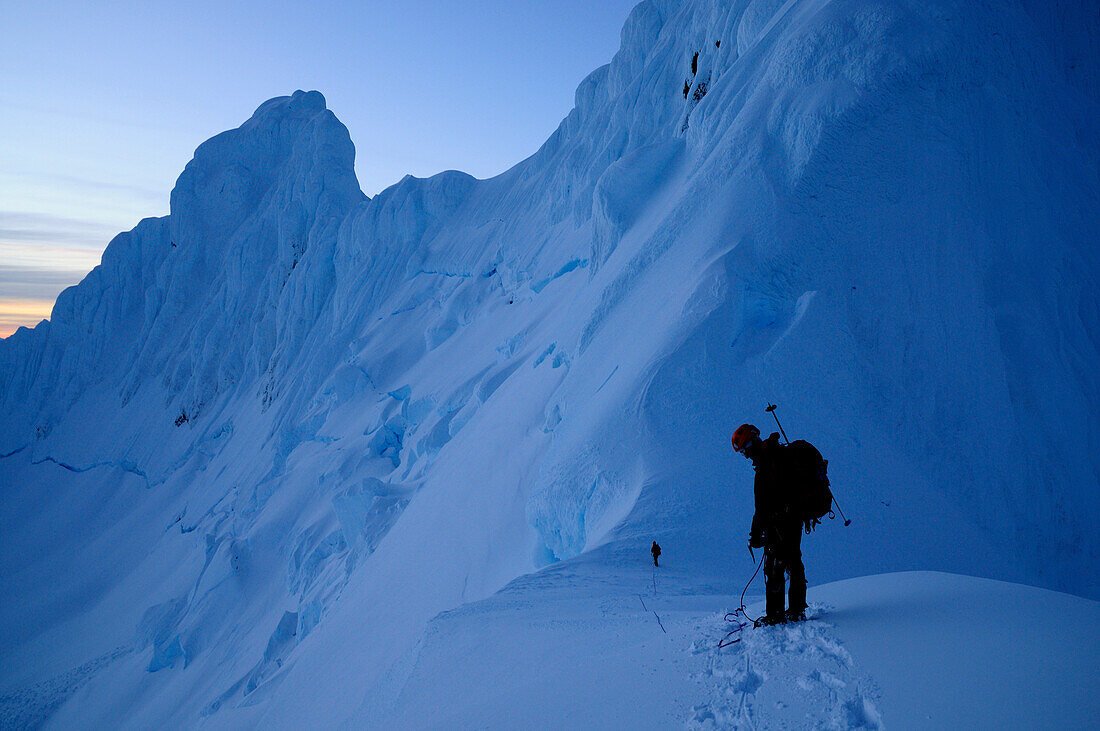 Two mountaineers below west summit of Monte Sarmiento, Cordillera Darwin, Tierra del Fuego, Chile