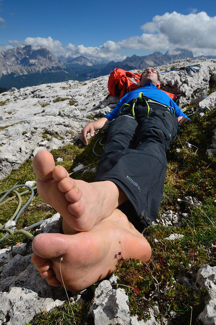 Climber resting on the summit of Torre Grande, Cinque Torri, Dolomites, Veneto, Italy