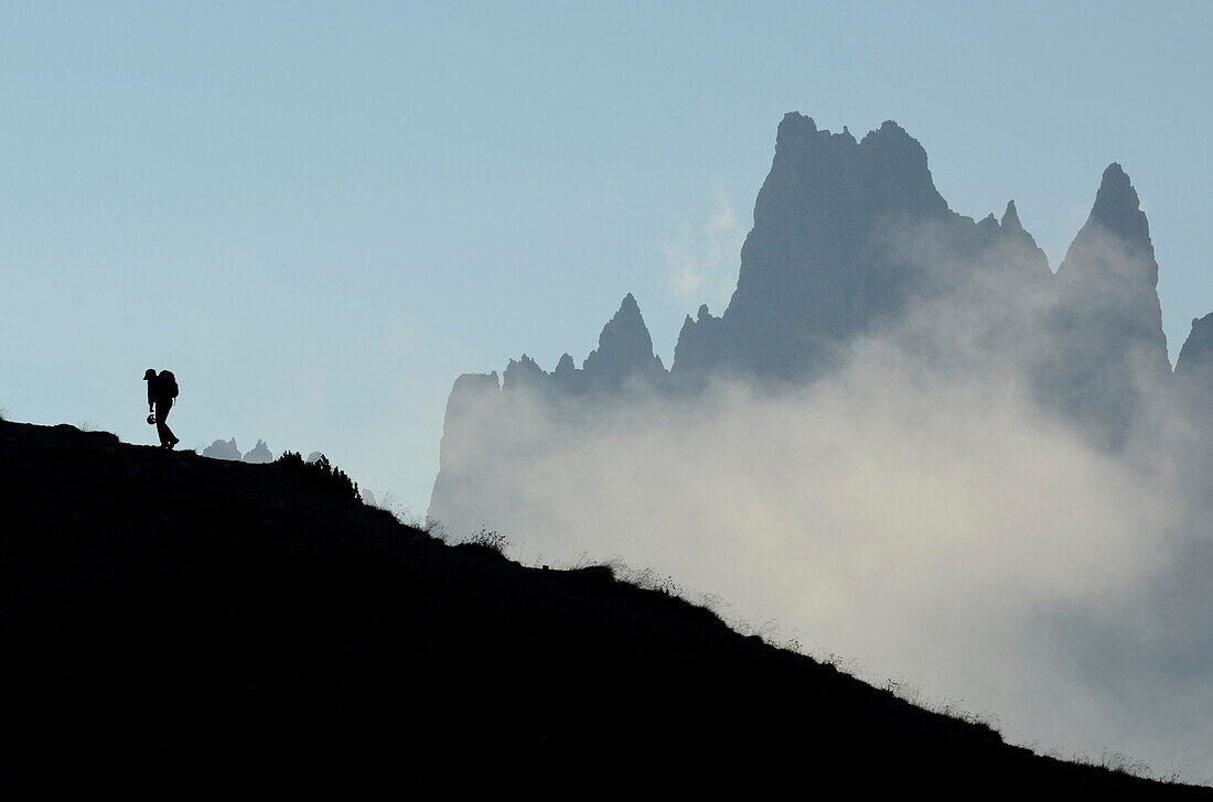 Climber ascending to Cinque Torri, Corda da Lago in background, Dolomites, Veneto, Italy