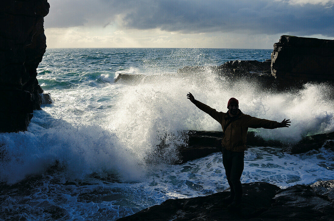 Man in front of roaring waves, Stoer, Highlands, Scotland, Great Britain