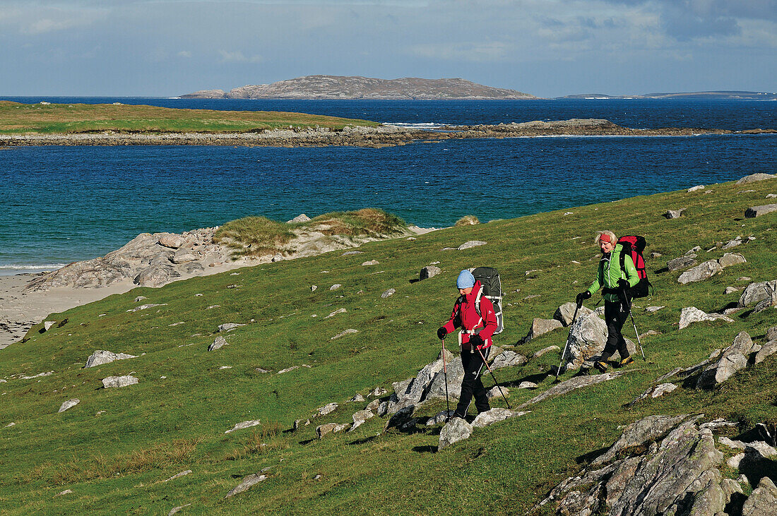 Hikers passing beach between Huisinis and Loch Crabhadail, Harris, Lewis and Harris, Outer Hebrides, Scotland, Great Britain