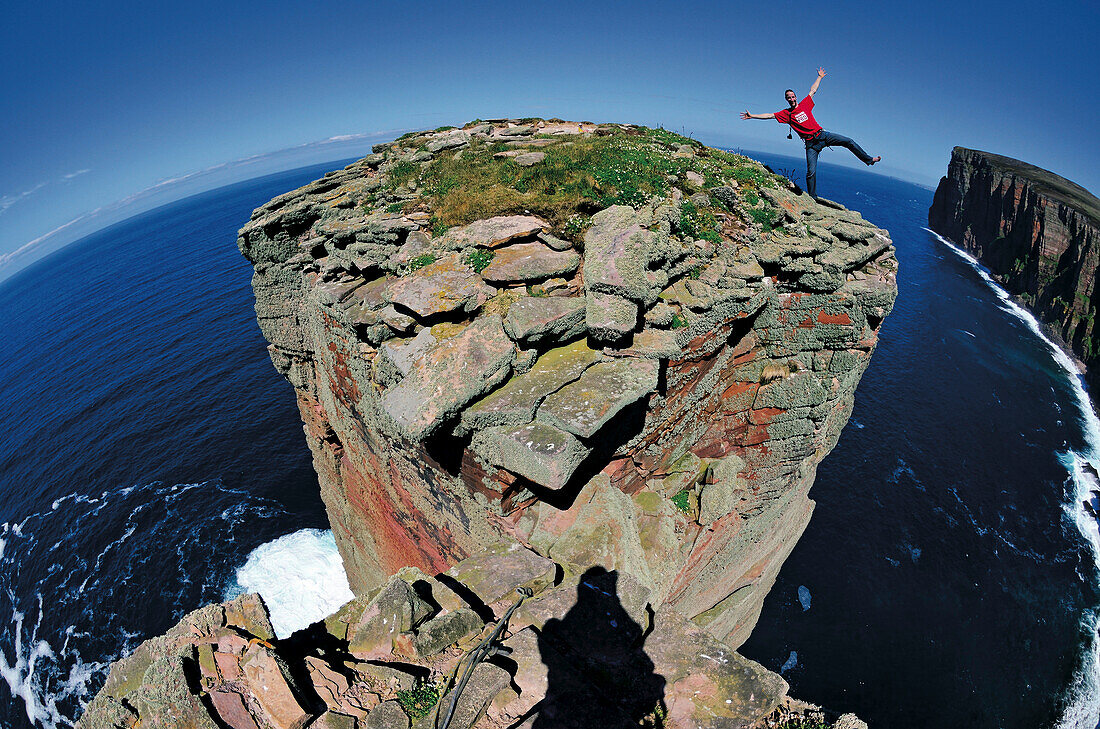 Climber on summit of the Old Man of Hoy, Orkney Islands, Scotland, Great Britain