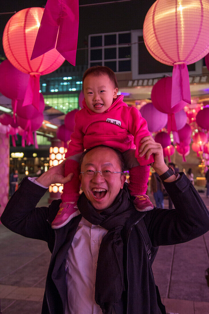 Fröhlicher Mann mit kleinem Mädchen auf seinen Schultern, Tsim Sha Tsui, Kowloon, Hongkong, China