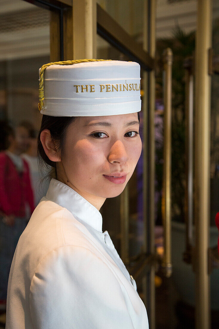Junge Türsteherin im The Peninsula Shanghai Hotel, Shanghai, China
