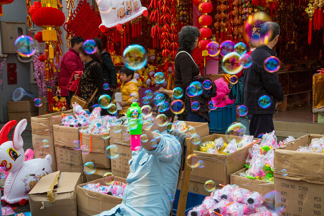 Mann mit Seifenblasen an einem Straßenmarkt nahe Altstadt, Nanshi, Shanghai, China