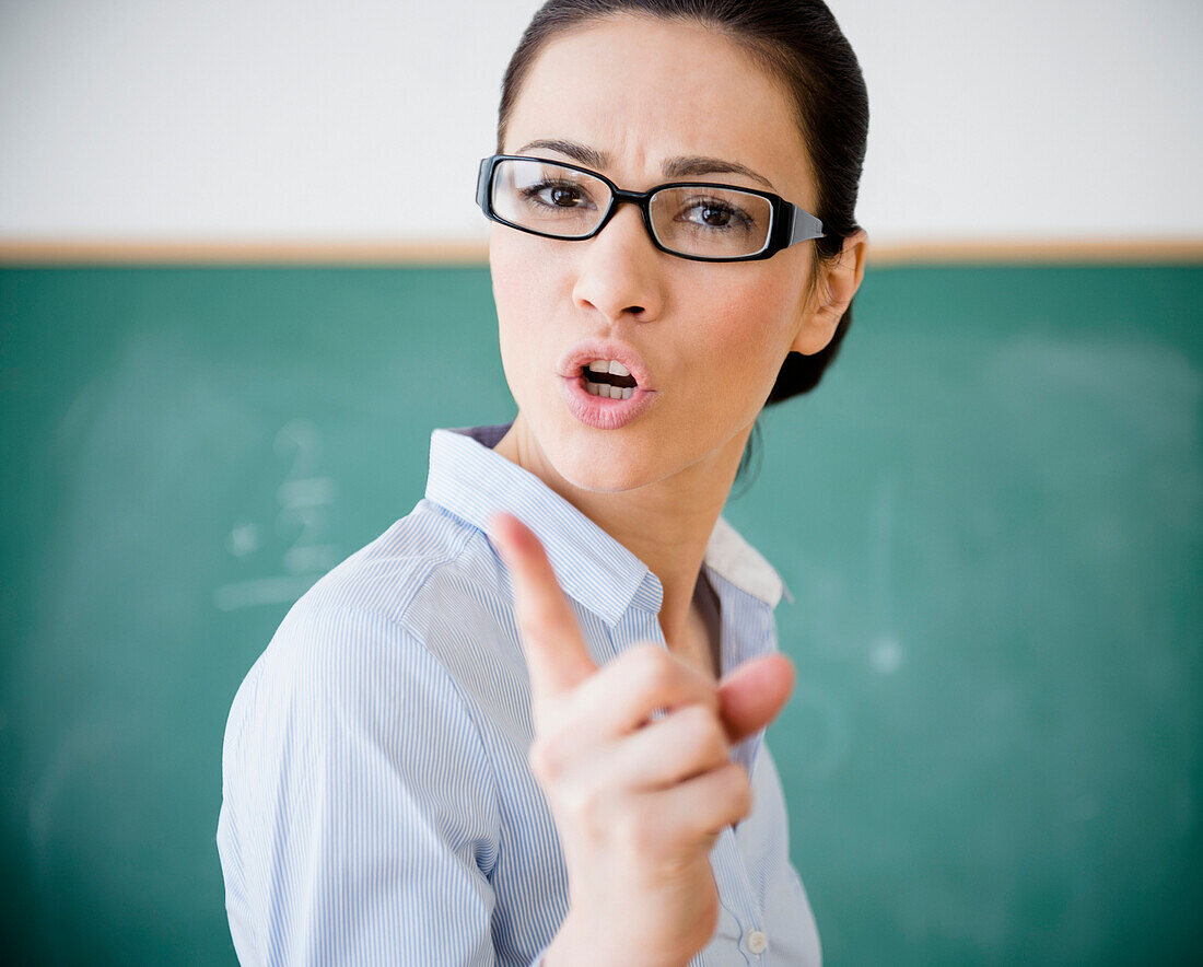 Caucasian teacher scolding in classroom, Jersey City, New Jersey, USA