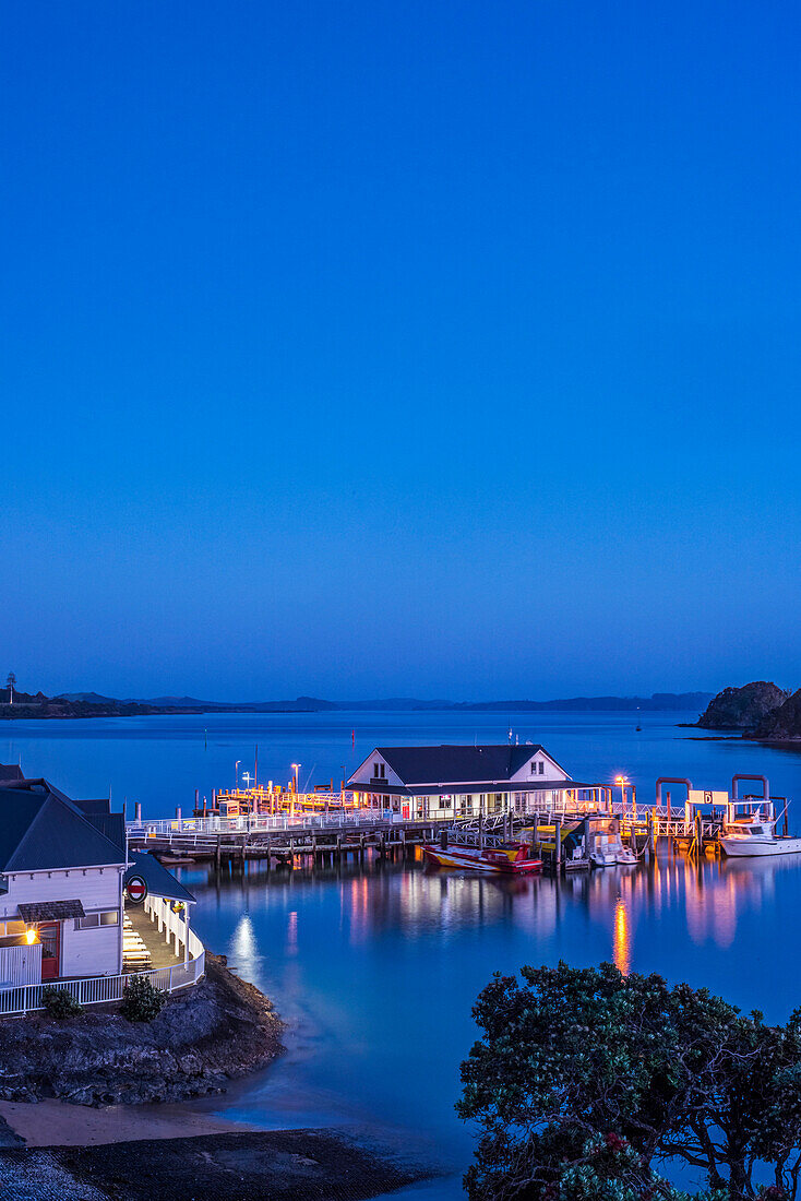 Illuminated building on water at dawn, Bay of Islands, Paihia, new zeland