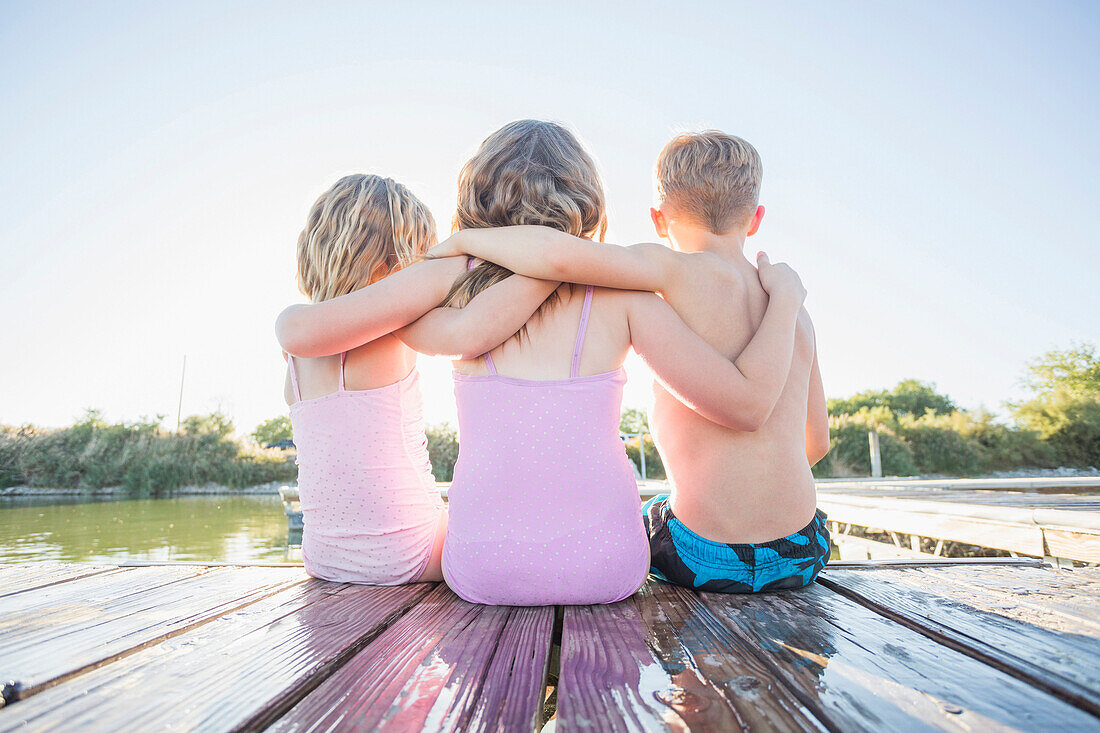 Caucasian children sitting on dock, American Fork, Utah, USA