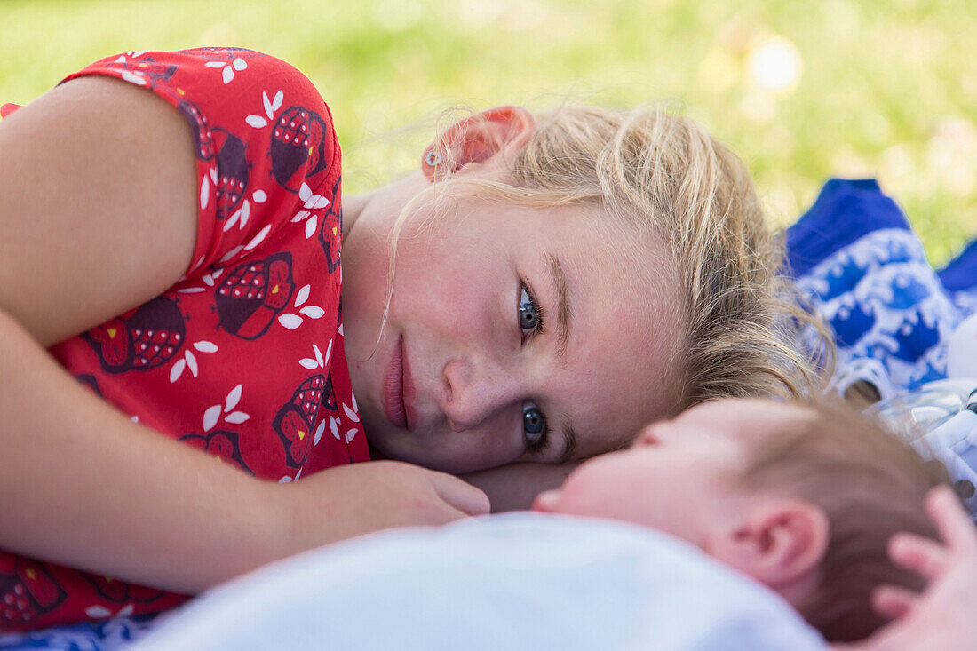 Caucasian girl laying with newborn baby brother, Santa Fe, New Mexico, USA