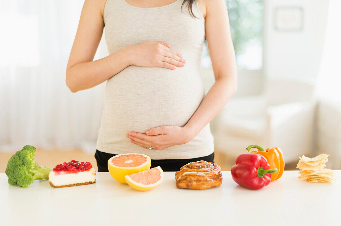 Gesunde und ungesunde Lebensmittel vor einer schwangeren Japanerin, Jersey City, NJ, USA
