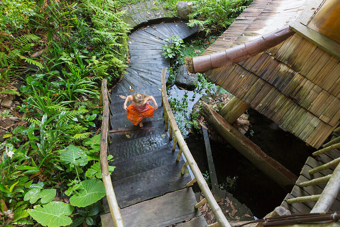 Caucasian girl running up steps in garden, Ubud, Bali, Indonesia, Ubud, Bali, Indonesia