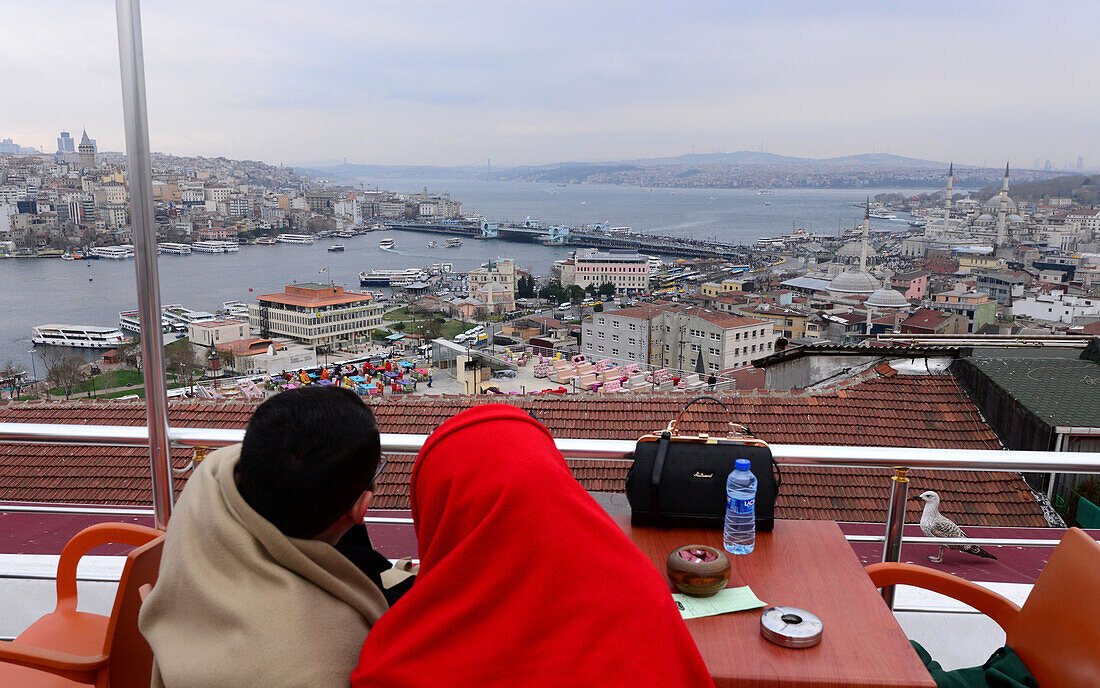 Couple sitting in a cafe with view to Galata bridge, Sultanahmet, Istanbul, Turkey