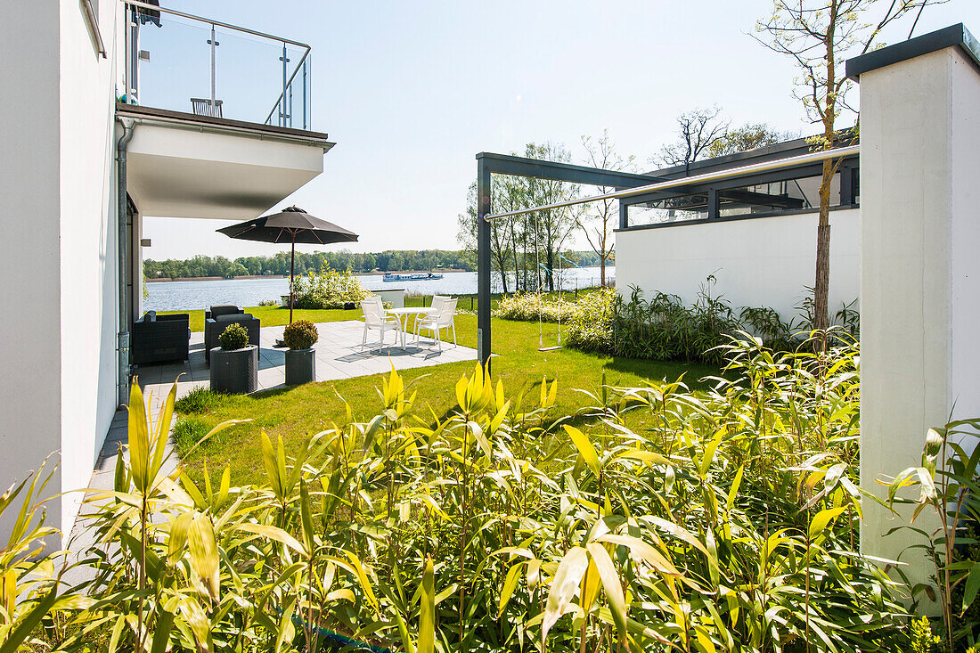 Terasse mit Blick auf Wasser in einer modernen Architekturvilla in Brandenburg, Deutschland