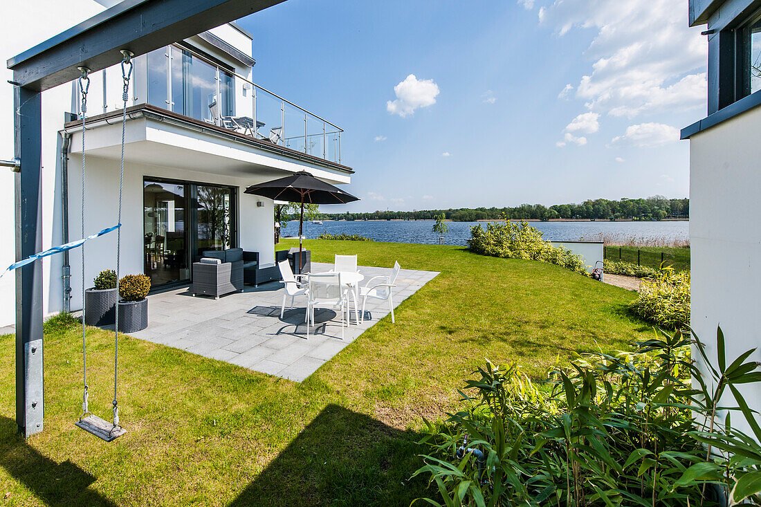 Terasse mit Blick auf Wasser in einer modernen Architekturvilla in Brandenburg, Deutschland