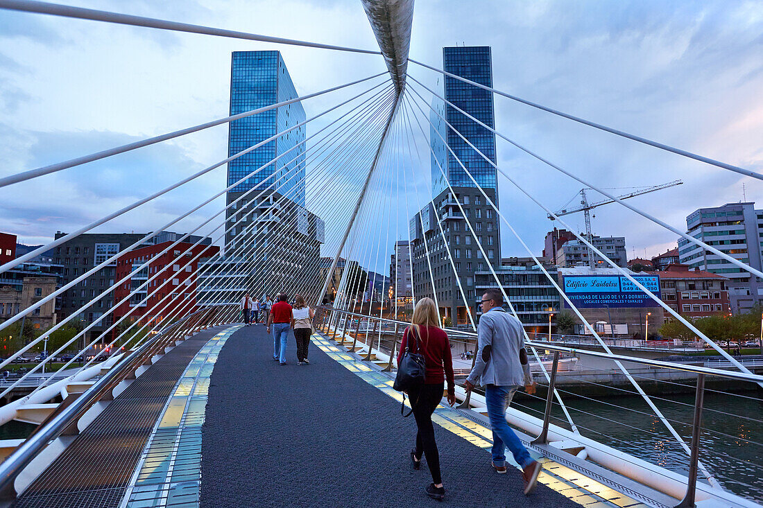 Die Zubizuri-Fußgängerbrücke von Santiago Calatrava über den Fluss Nervion und die Isozaki-Türme des japanischen Architekten Arata Isozaki. Bilbao. Bizkaia. Baskenland. Spanien.