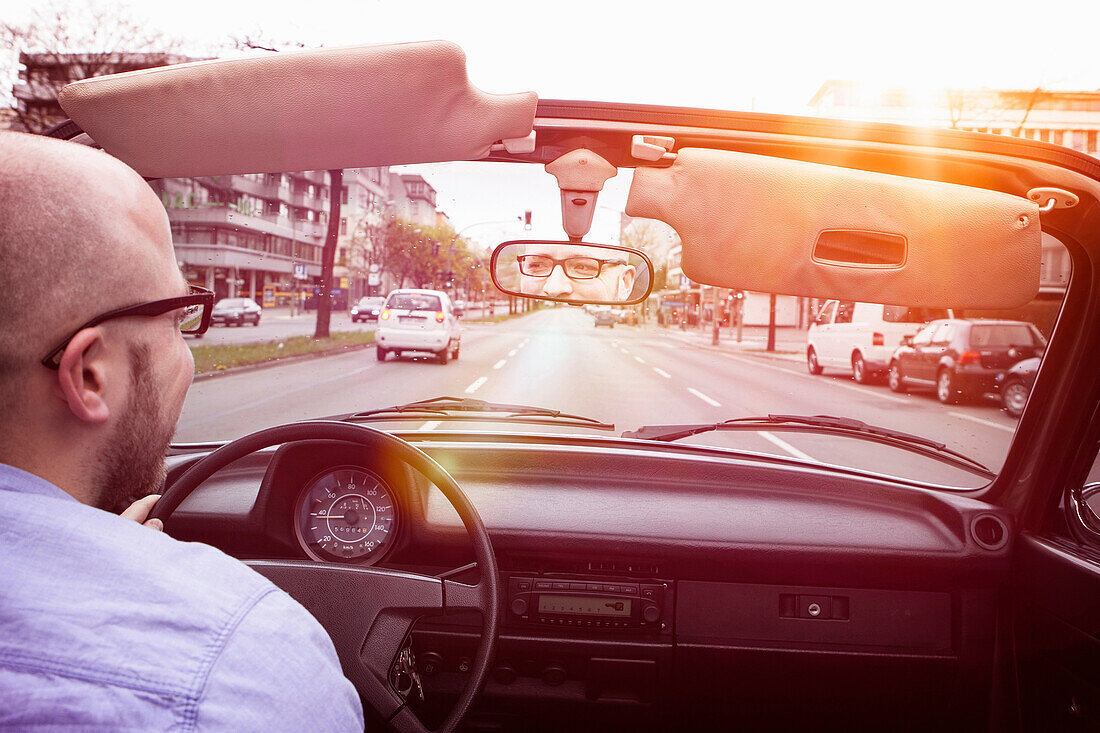 Young man driving convertible car