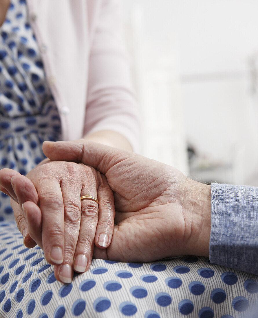 Senior couple holding hands, close up