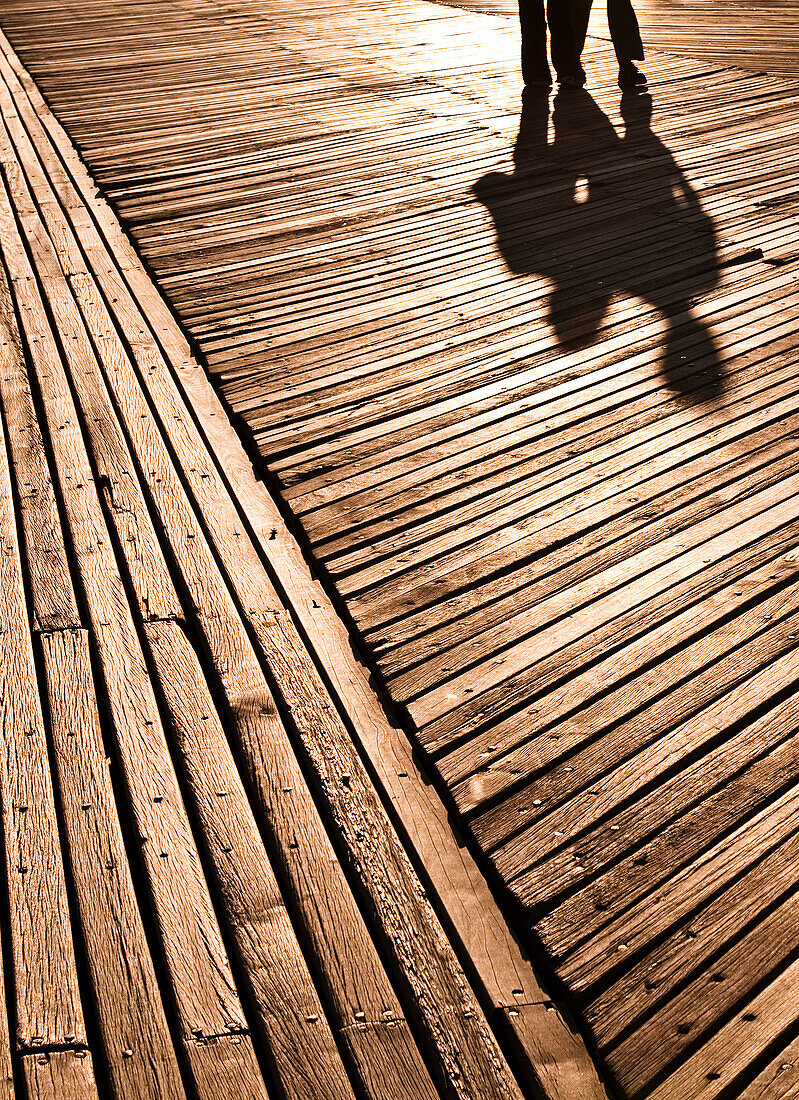 Shadows of two people on boardwalk, Coney Island, New York, USA