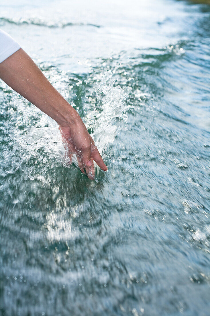 Person putting hand in sea water