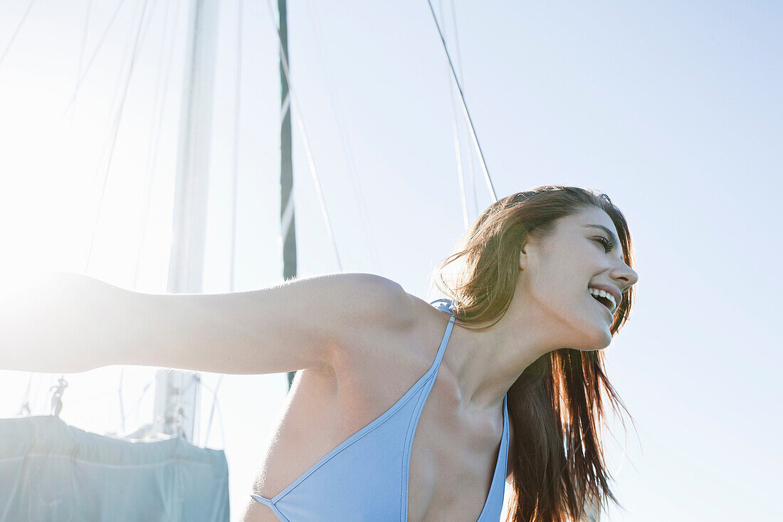 Young brunette woman on yacht, laughing