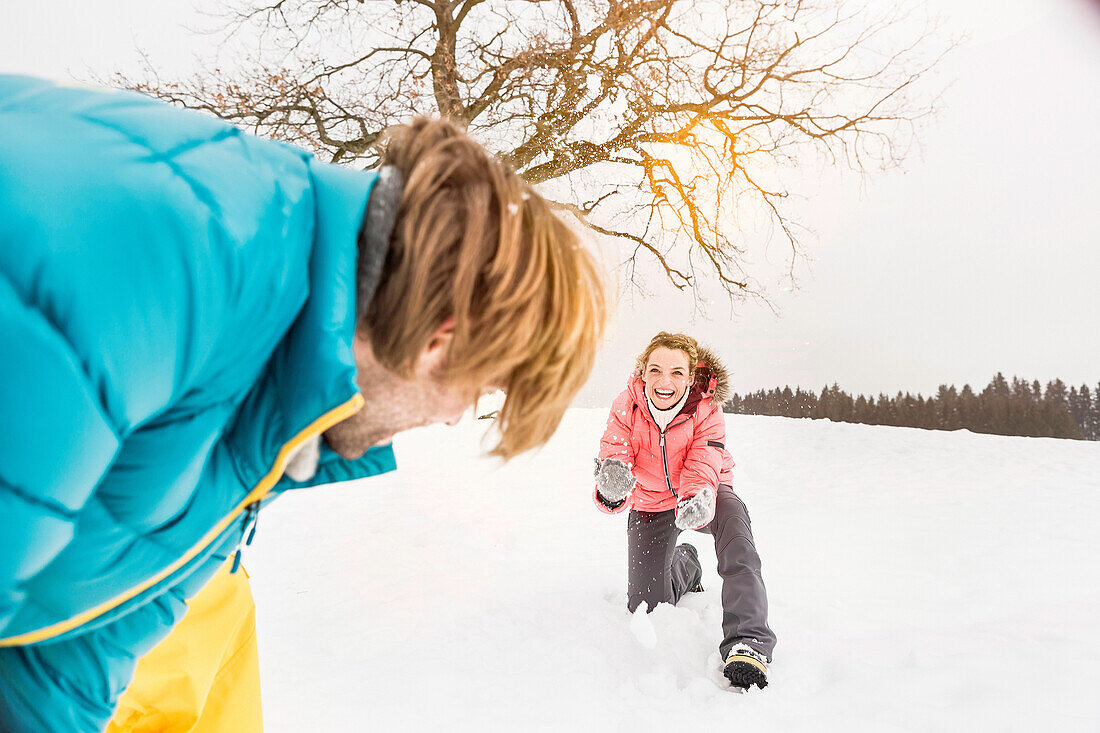 Couple play fighting in snow