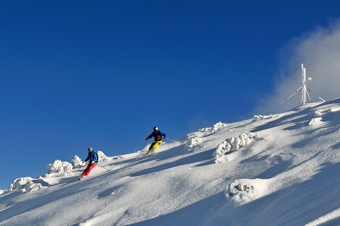 Zwei Skifahrer fahren ab, Skigebiet Steinplatte, Waidring, Tirol, Österreich
