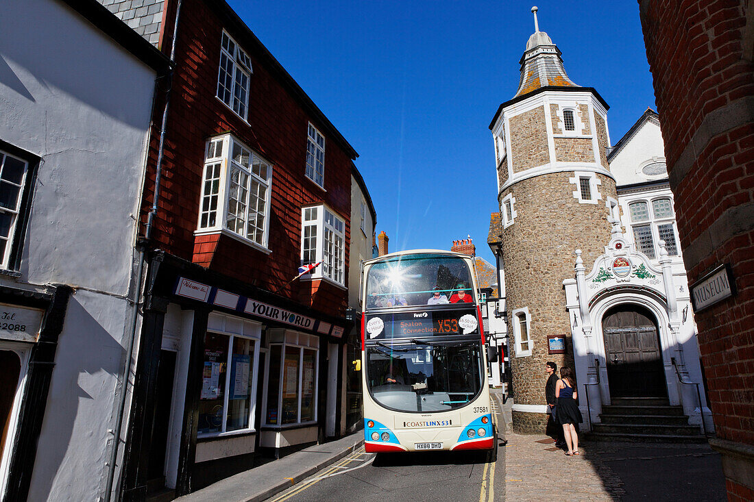 Bus fährt durch die Bridge street mit seiner Guildhall, rechts, Lyme Regis, Dorset, England, Grossbritannien