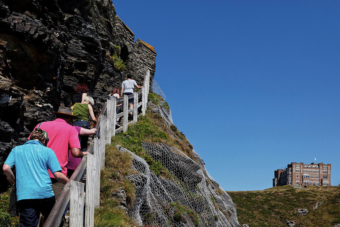 Touristen erklimmen eine Leiter zum Burg von Artus und Camelot Castle Hotel, Tintagel Castle, Tintagel, Cornwall, England, Grossbritannien
