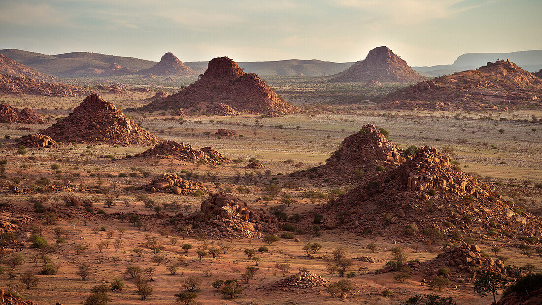 Blick in die Ferne aus zahlreiche Felshügel im Damara Land bei Sonnenuntergang, typische Landschaft, Damaraland, Namibia, Afrika
