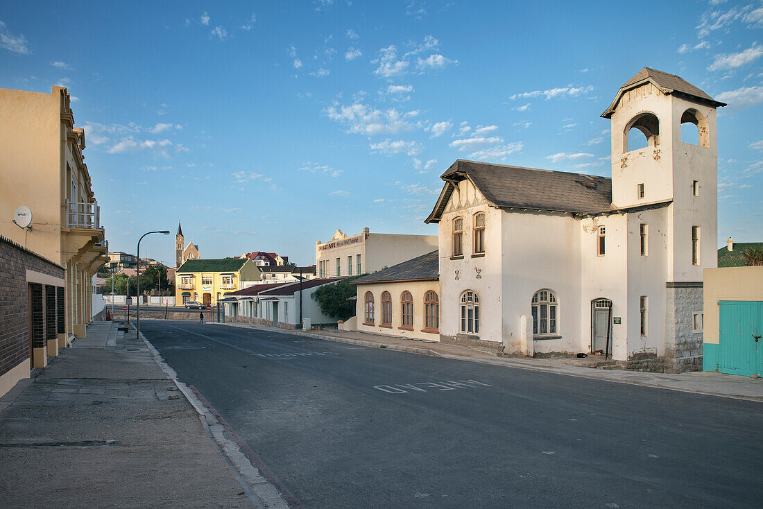 Typical German colonisation Art Nouveau architecture with rock church in the background, Luderitz, Namibia, Africa