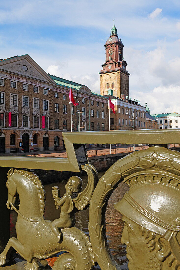Figures on a bridge rail over the Stora Hamn canal with the city hall in the background, Gothenburg, Sweden