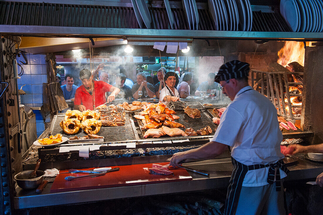 Köche grillen Steak und Fleisch in einem Parilla Restaurant, Mercado del Puerto, Montevideo, Montevideo, Uruguay