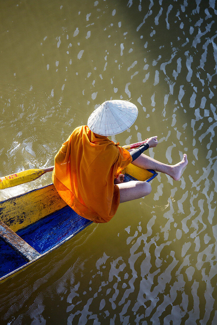 Buddhistische Mönche in einem Ruderboot auf dem Mekong-Fluss in Paske, Laos.