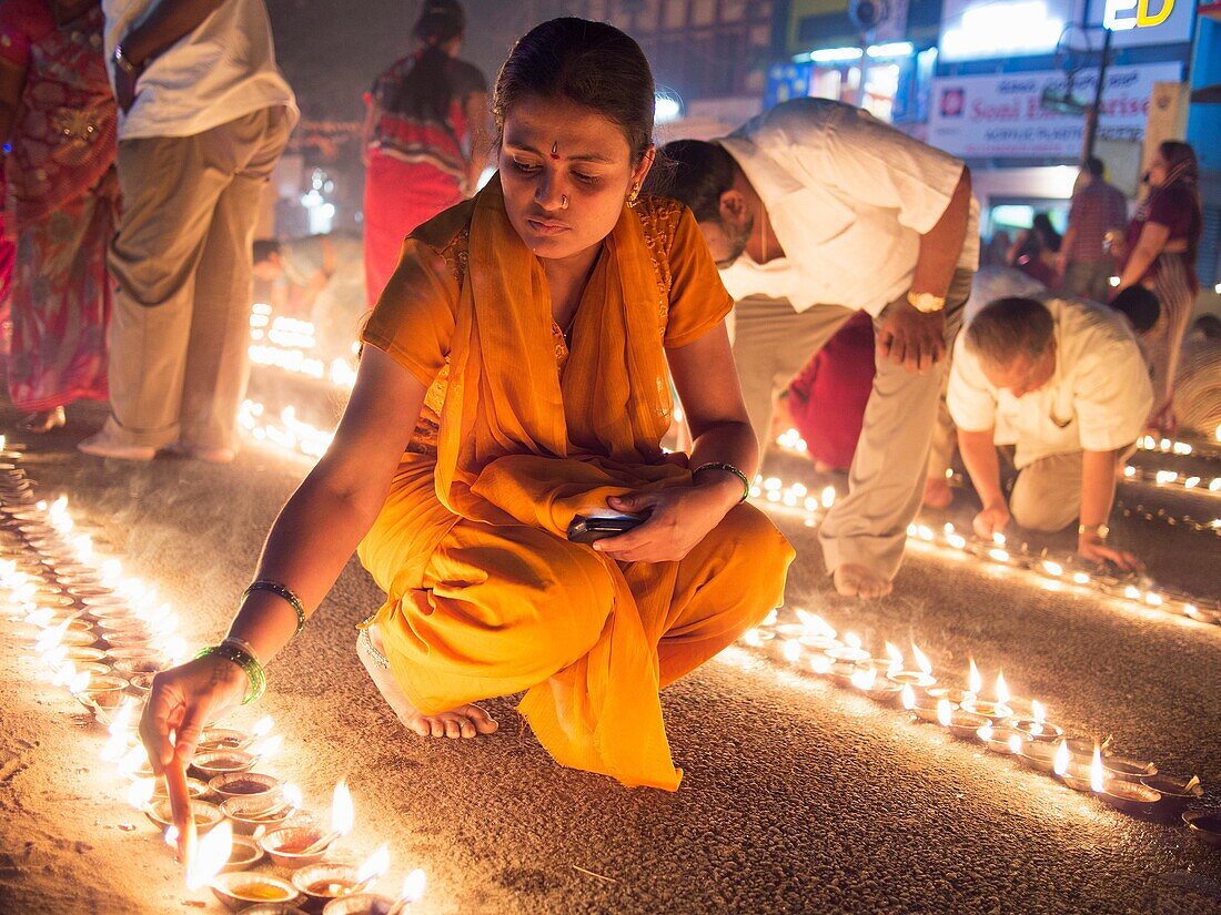 Indians light oil lamps in the street for a Hindu festival in Bangalore, Karnataka, India.