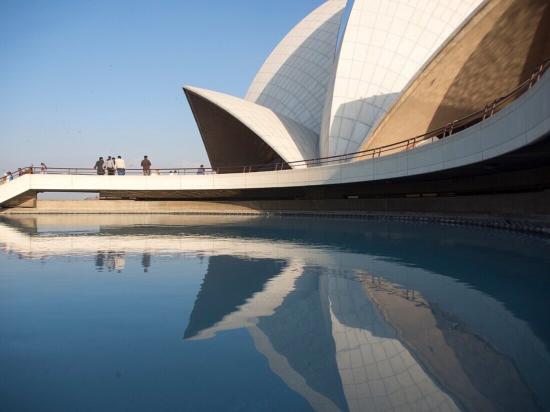 Lotus temple reflecting in pond at New Delhi, India.