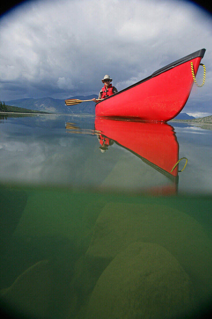 Vignetted Underwater Image Of A Man Canoeing On Kusawa Lake, Yukon