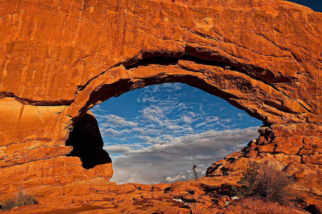 People Taking Photos Through The North Window Arch, Arches National Park, Utah