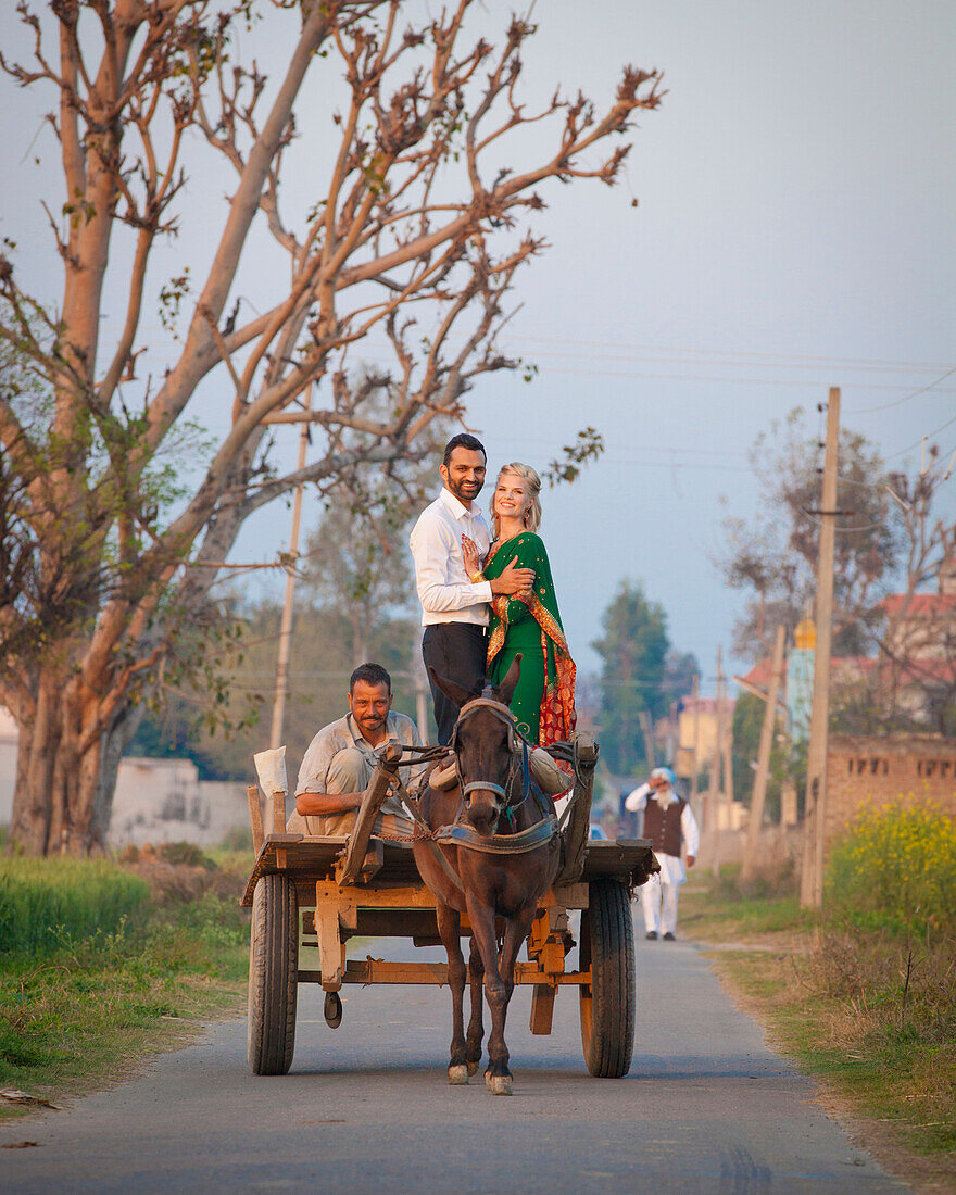 'A Mixed Race Couple Standing In An Embrace On A Cart Being Pulled By A Horse; Ludhiana, Punjab, India'