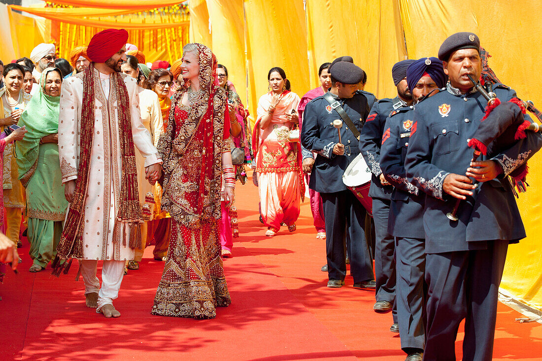 'A Bride And Groom Walk Hand In Hand After Their Indian Wedding Ceremony; Ludhiana, Punjab, India'