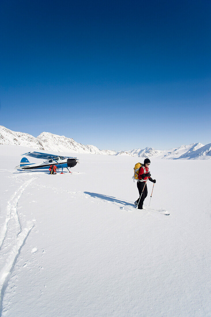 A Backcountry Skier And Snowboarder Get Dropped Off By A Cessna 170 Ski Plane On Eagle Glacier In The Chugach Mountains On A Sunny Day, Southcentral Alaska, Winter/N