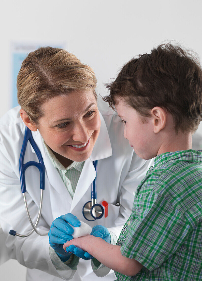 Doctor caring for small boy with injury