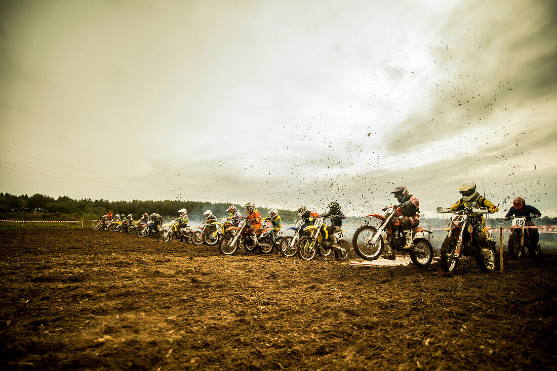 Group of boys on motorcycles at motocross start line